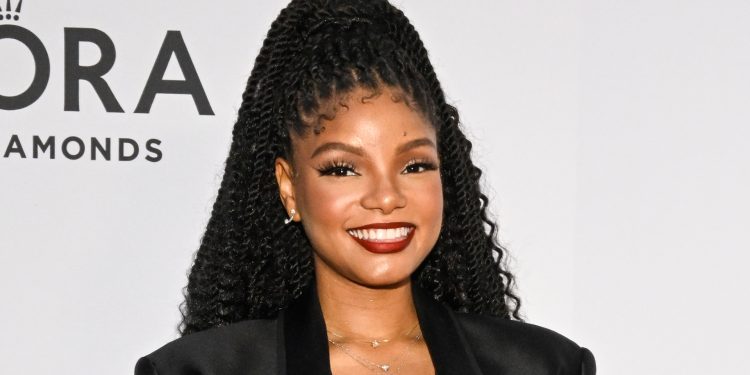 halle-bailey-hides-her-stomach-under-table-and-baggy-t-shirt-as-she-indulges-in-big-…